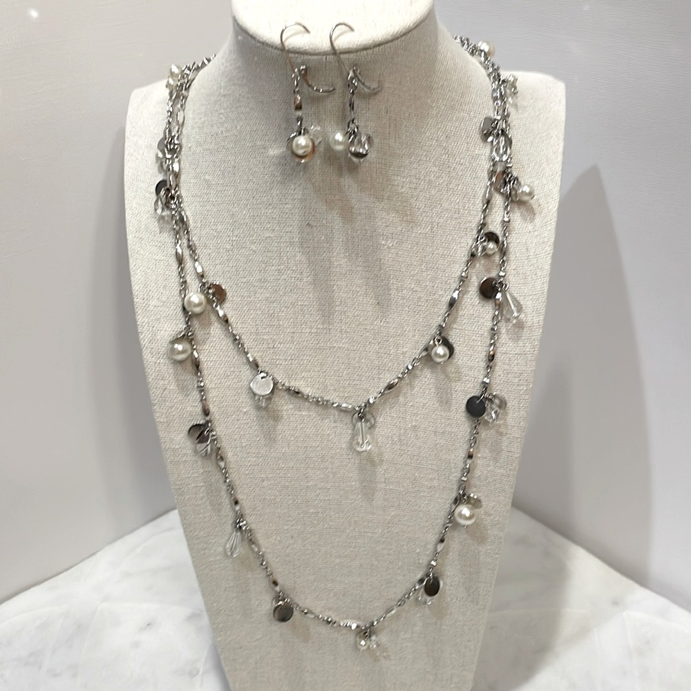 Long silver necklace with pearl and crystal accents and matching earrings.